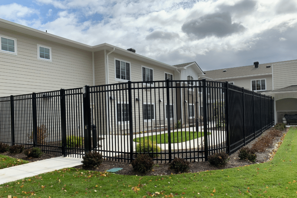 Tall black ornamental aluminum fence surrounding landscaped courtyard at commercial property in Waterbury CT